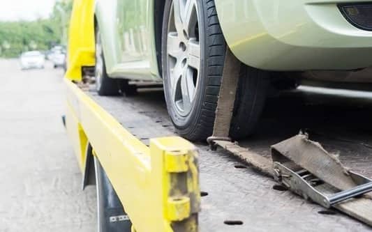 Securing a vehicle's wheel to the flatbed during pickup